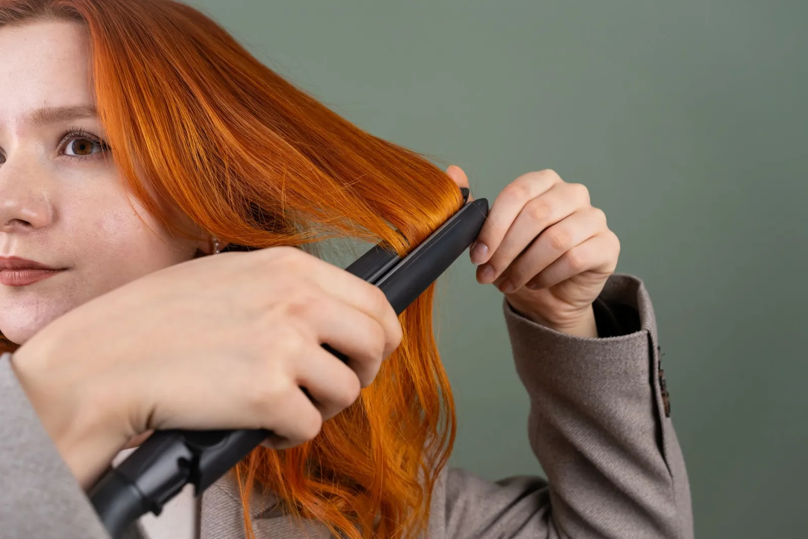 donna che usa la piastra per capelli